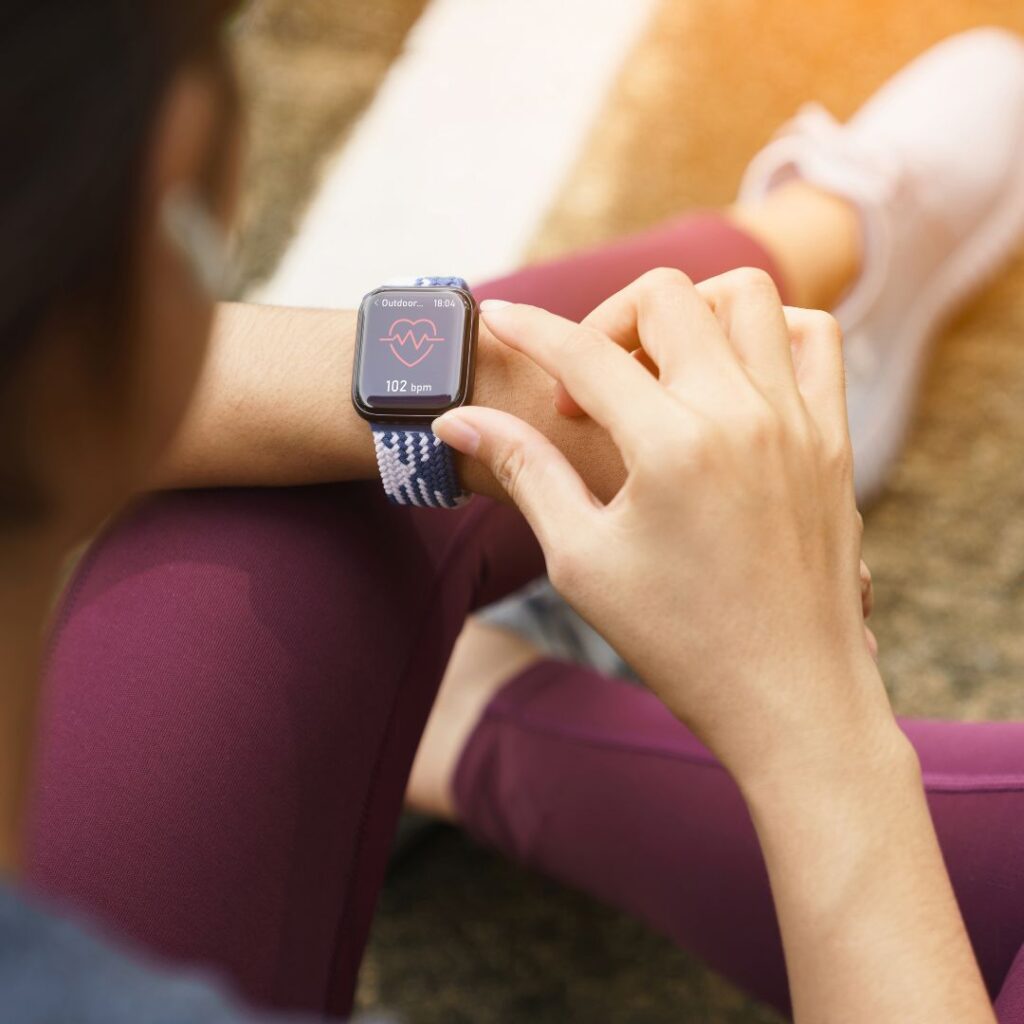 An apple watch on a females wrist, out running