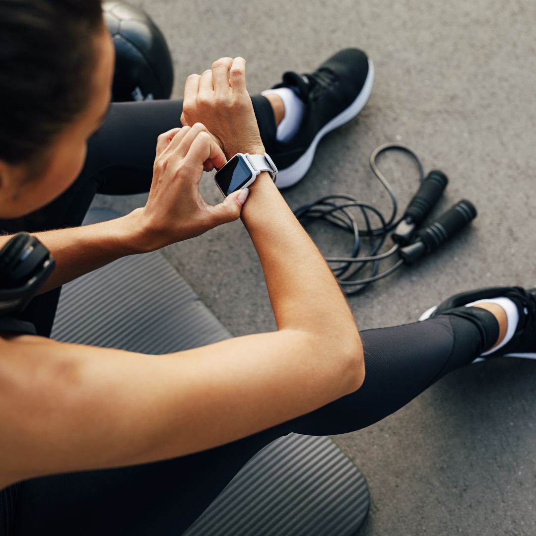 A woman checks her apple watch in the gym