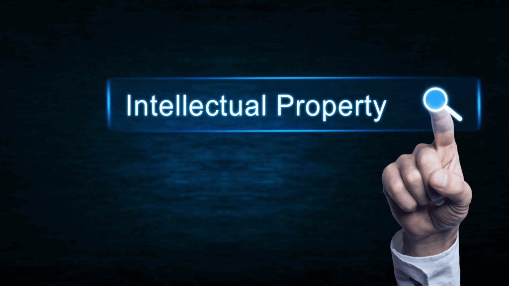 Intellectual property words with a hand pointing towards a search icon.