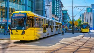 Yellow tram moving through Manchester city centre