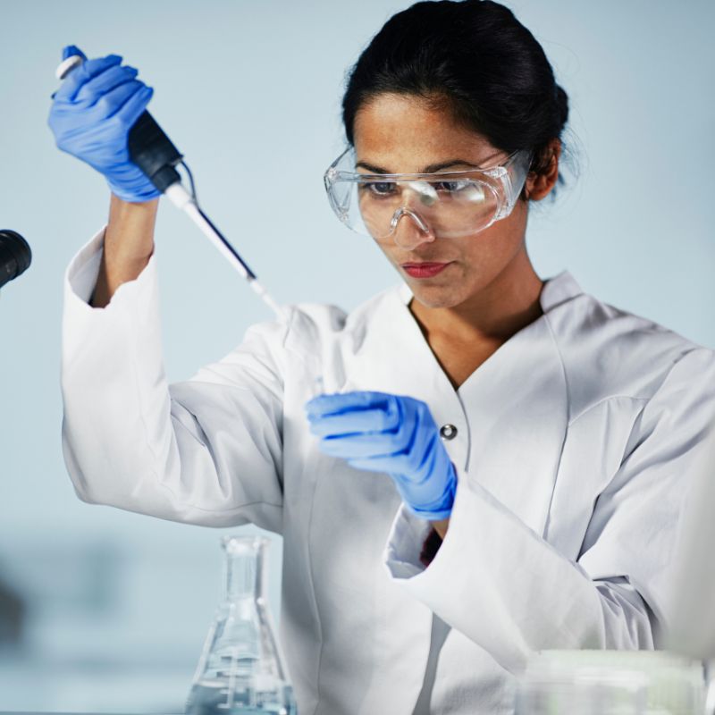 A female bio scientist holding a pipette as she conducts scientific research.