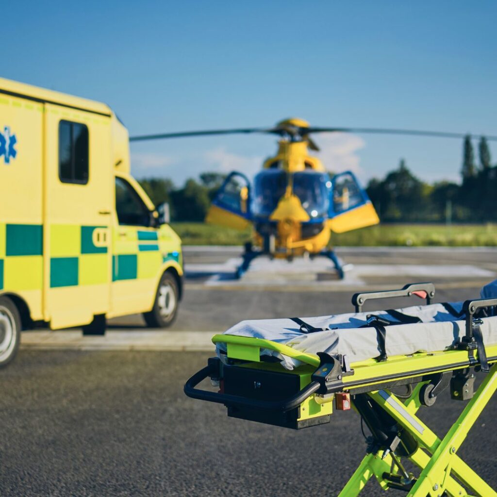 An ambulance and air ambulance, with a stretcher in the foreground