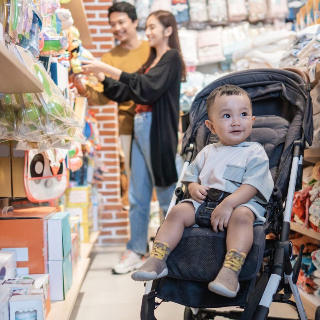 A baby boy in his pram whilst his parents shop for new baby clothes