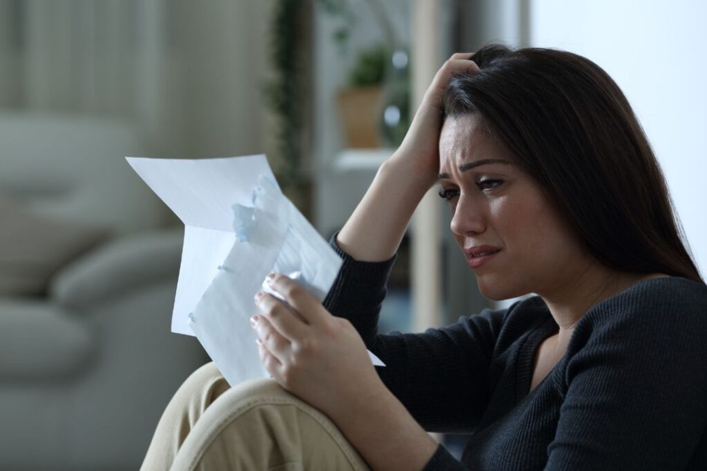 An anxious female business owner opening a cease and desist letter.