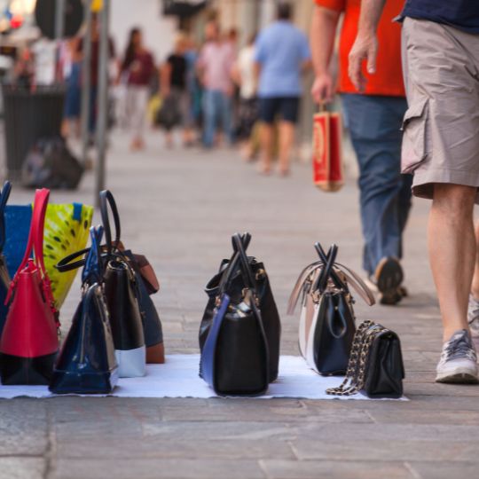 Counterfeit bags laid out on the pavement