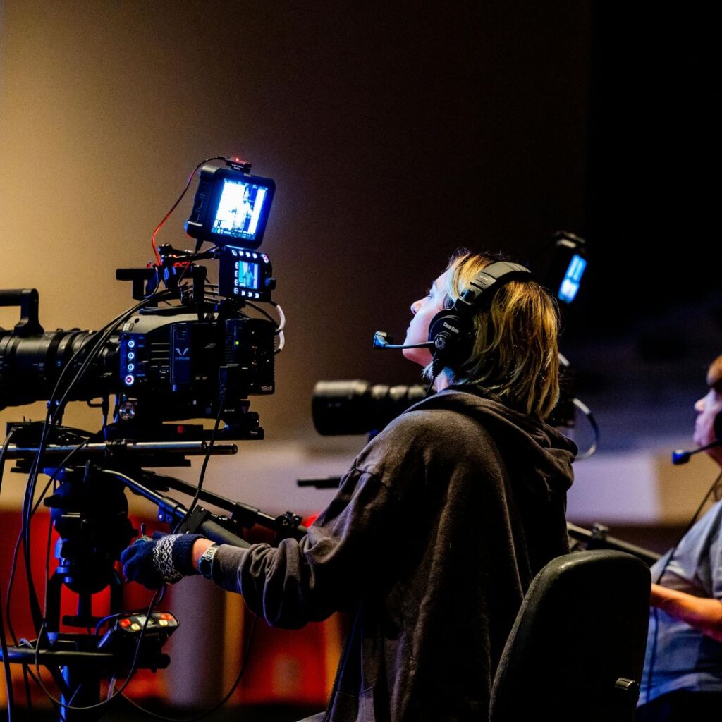 A female behind a camera on a tv set