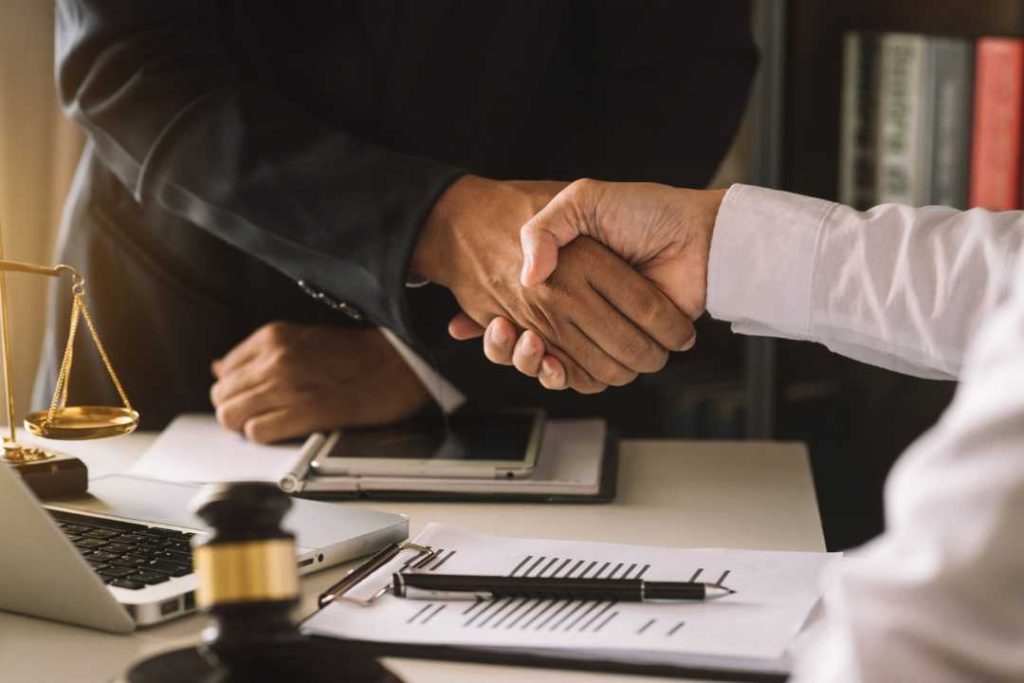 A patent lawyer and client shaking hands in a lawyers office.