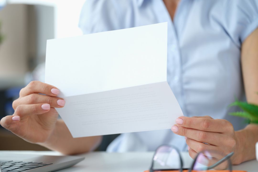 A female business owner opening a letter from Mathys and Squire.