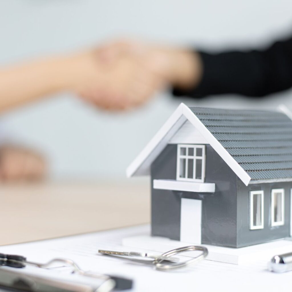 An image to symbolise real estate, someone making a deal on a house purchase.