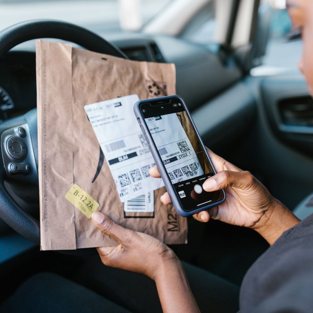 An Amazon delivery employee scanning in a parcel.