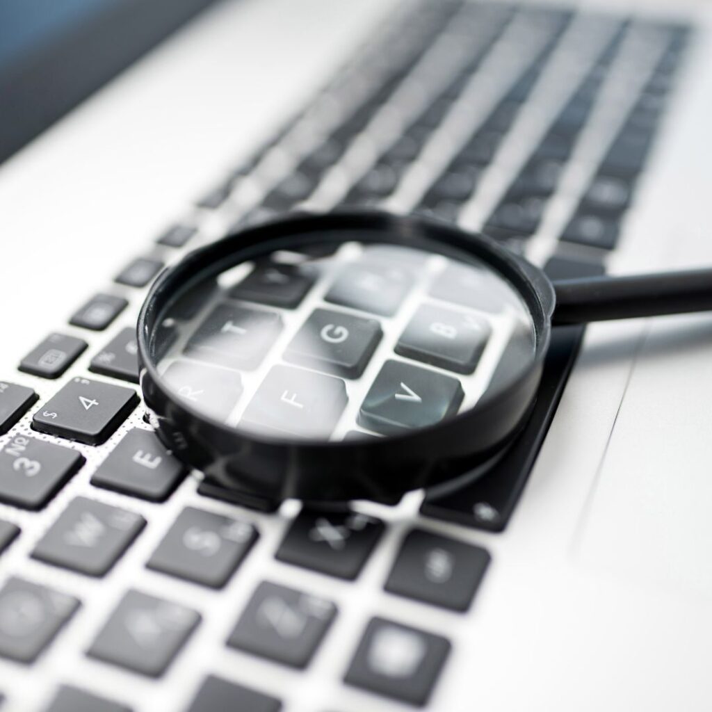 A magnifying glass laid on a computer keyboard
