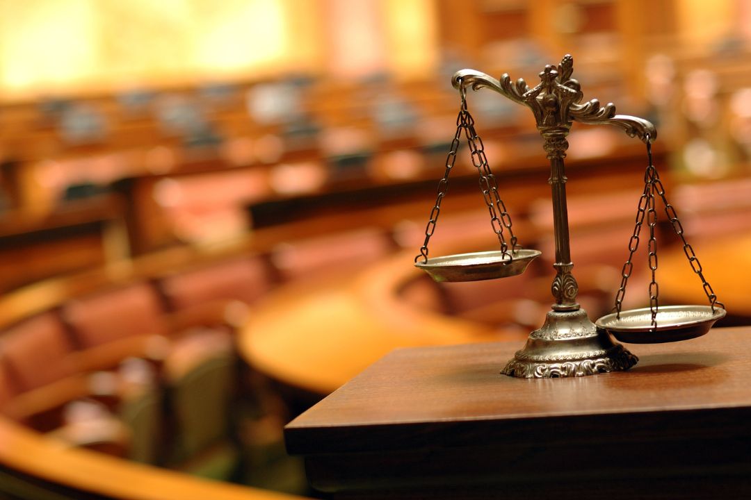 A blurred shot of the Unified Patent Court with scales on the table.