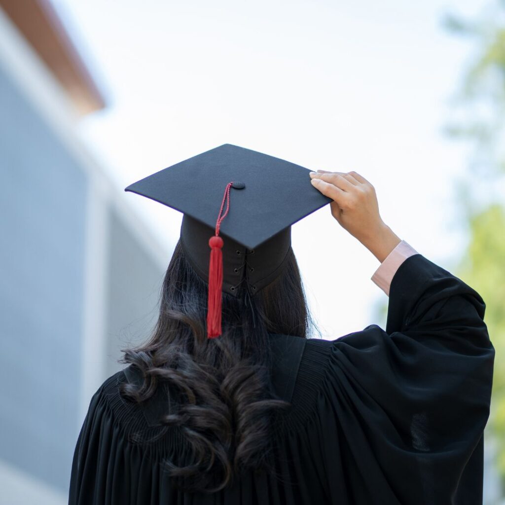 University student holding onto her mortarboard