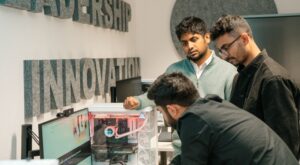 Innovators crowded around an invention for inspection