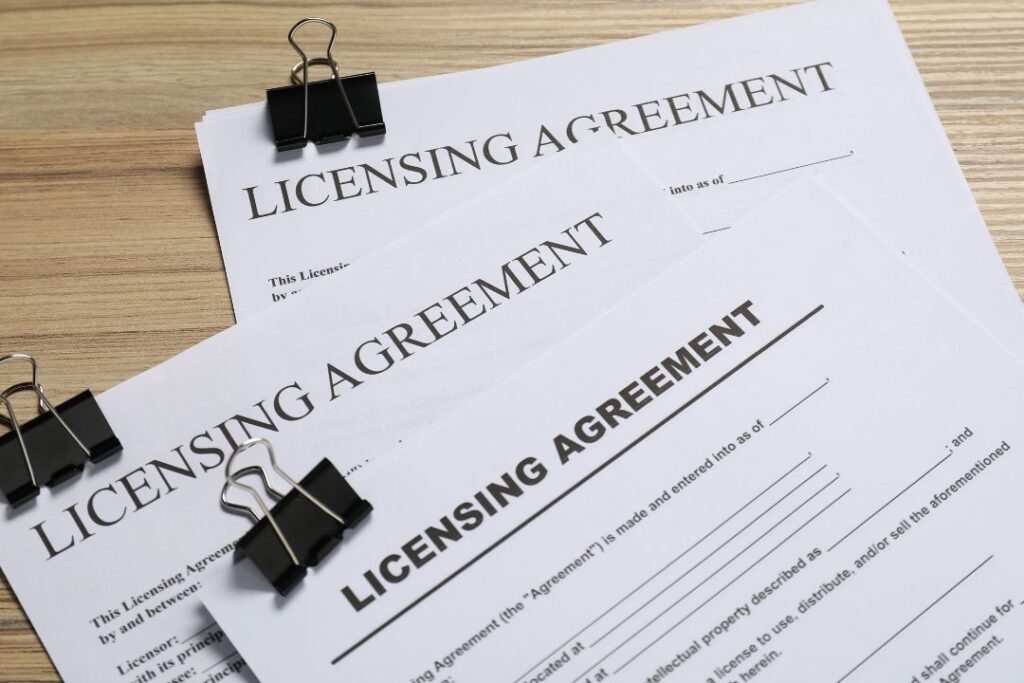 A stack of three licensing agreements on a desk