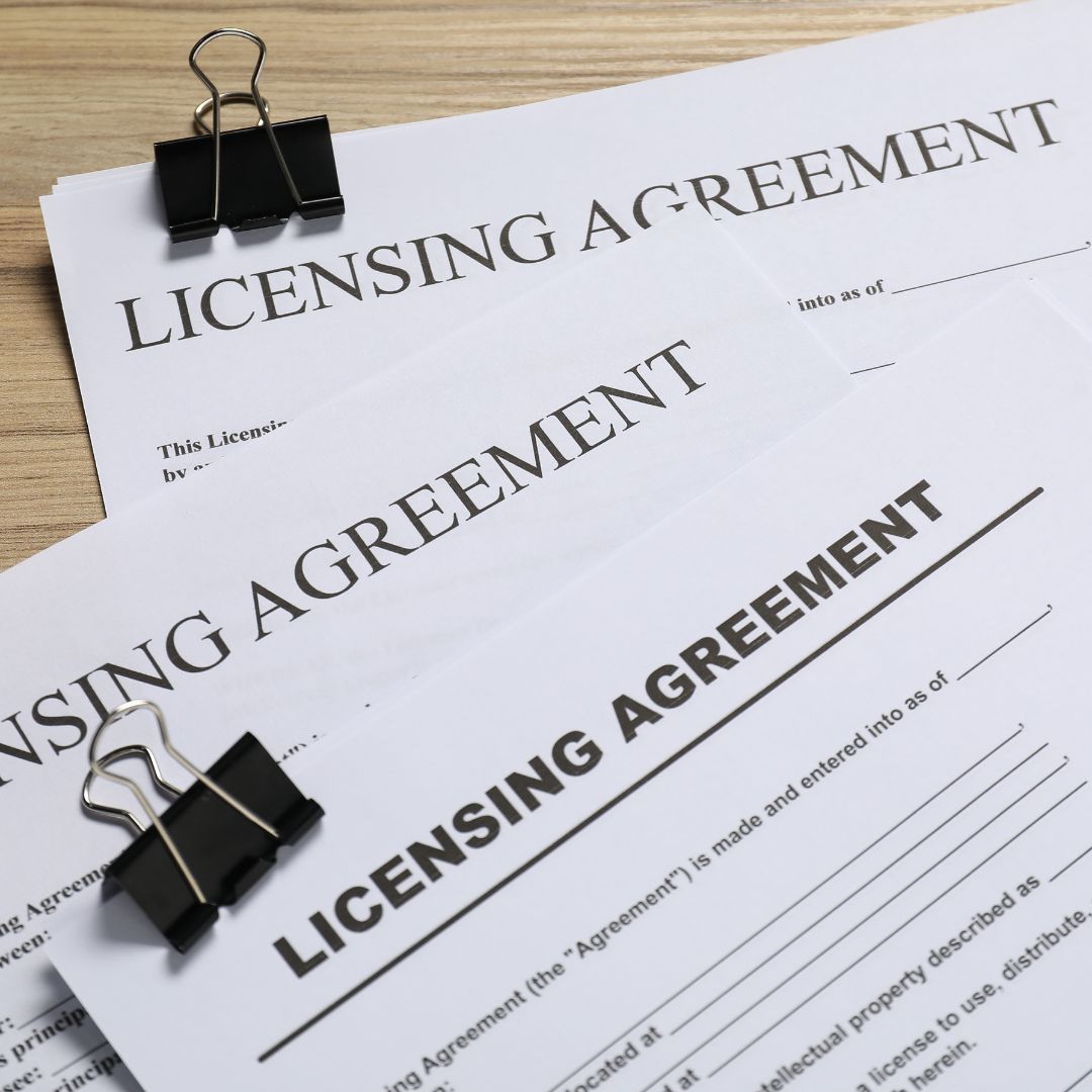 A stack of licensing agreements on a desk